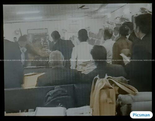 "A courtroom scene where an advocate is being physically overpowered by a group of determined women. The advocate, a middle-aged man in a dark suit, is shown in a defensive posture, while the women, dressed in professional attire, are standing around him. One woman holds him by the collar, while others stand firmly with confident expressions. The atmosphere is intense, and the courtroom setting includes wooden paneling, a judge’s bench in the background, and witnesses observing the unusual turn of events. The women’s faces express anger and determination, contrasting with the surprised and defeated look of the advocate."